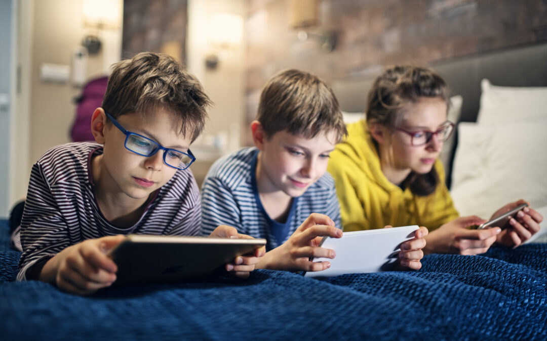 Three male children lounging with tablets indicating responsible and courteous use of online