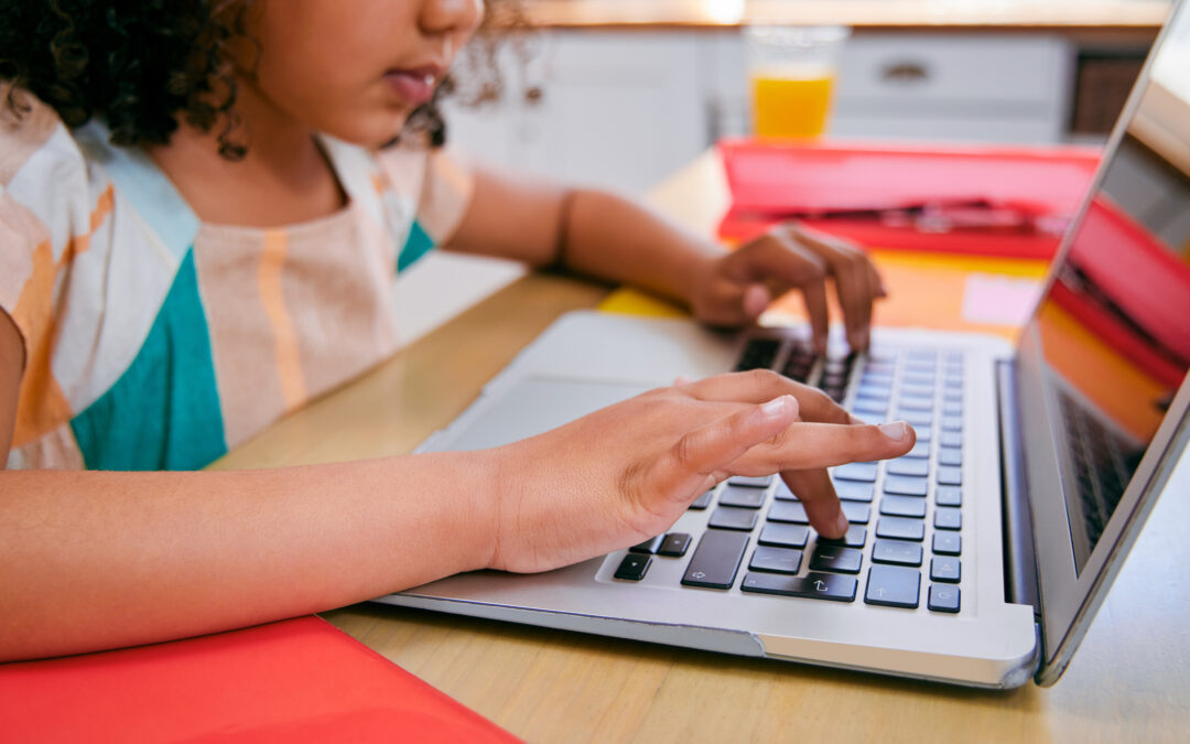 Young student practicing keyboarding on laptop computer