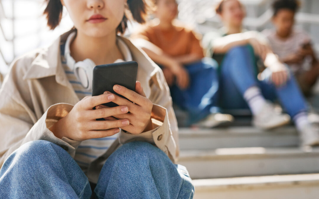 Teenage student on smartphone differentiating cyberbullying and conflict