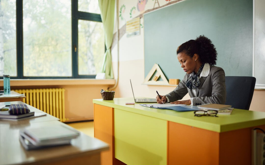 African American teacher in classroom planning digital literacy curriculum