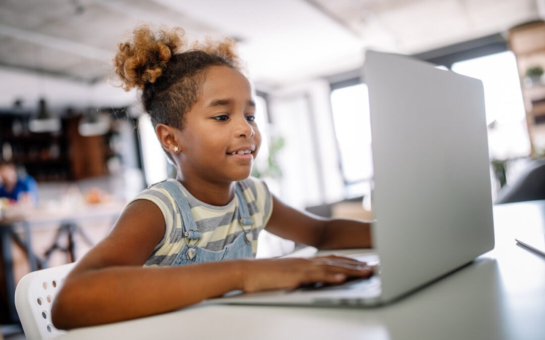 Young female student practicing digital literacy skills on laptop in classroom