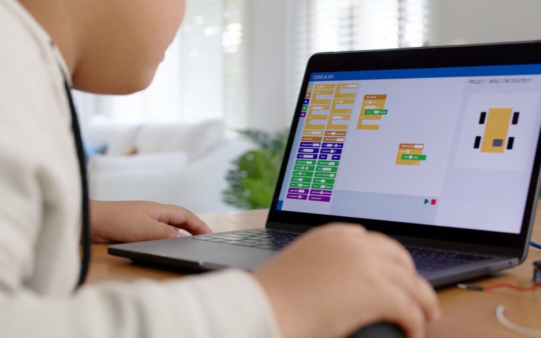 Young student practicing block based coding on laptop