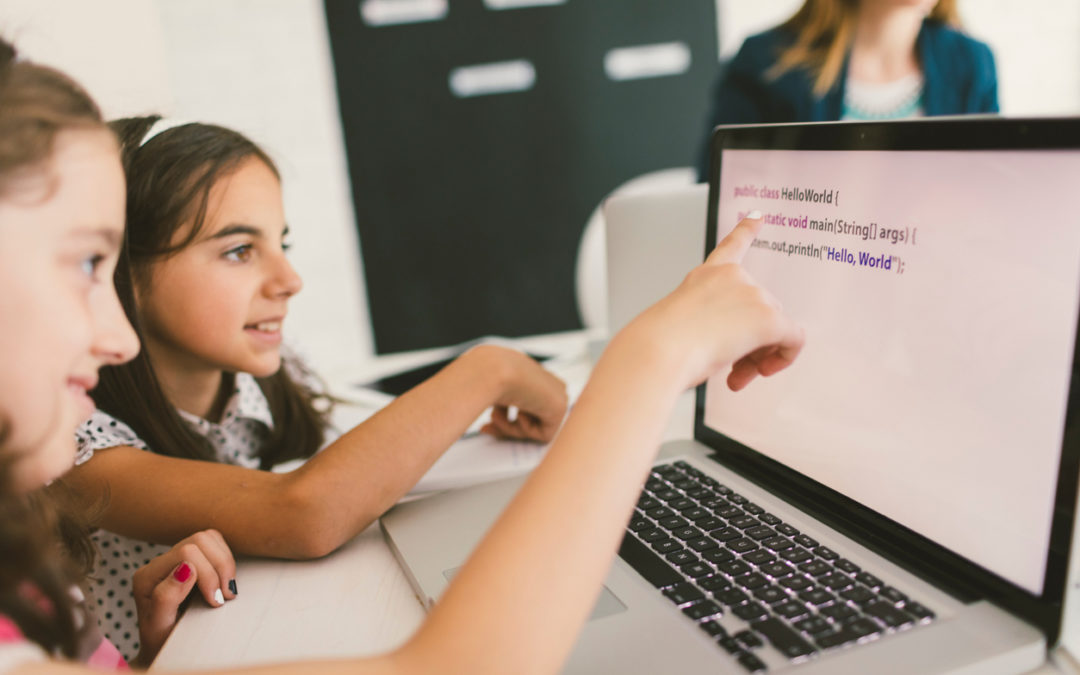 Two female students learning important coding skills on laptop